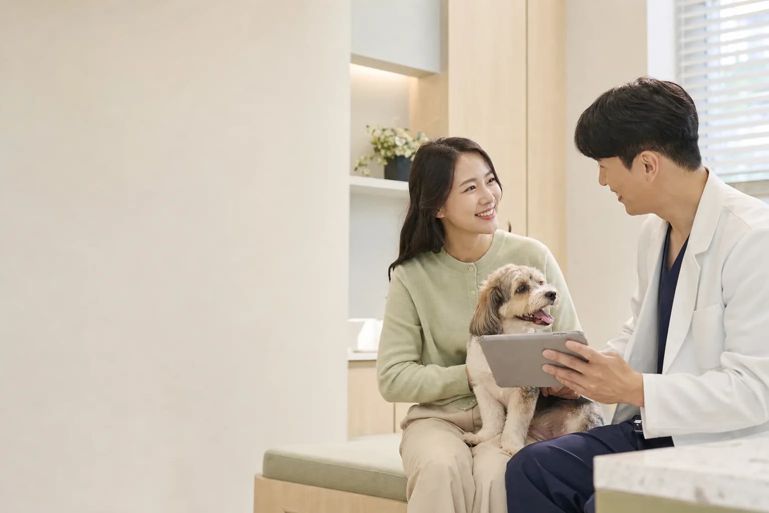 보호자와 반려견이 수의사에게 진료 상담을 받는 모습
